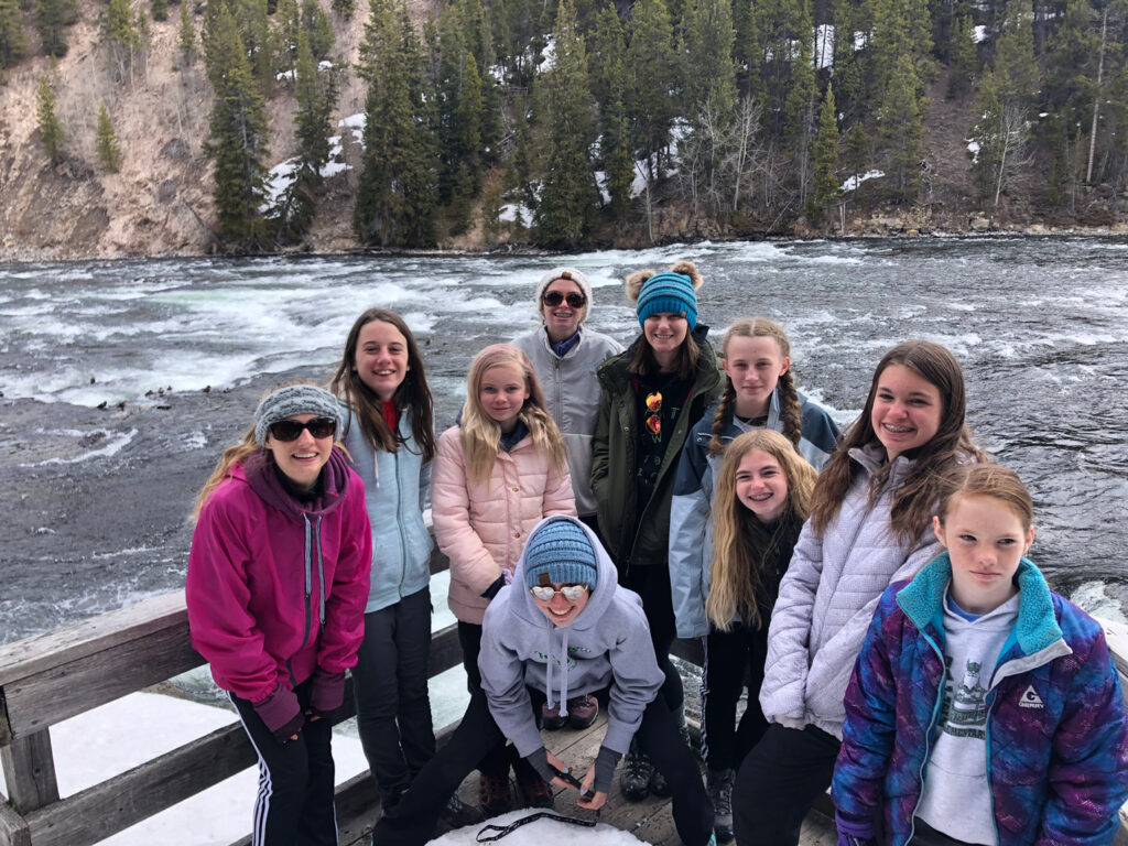 youth educational adventures group posing together by a rushing river