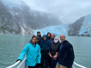 adventures for all group posing in boat by ice covered mountains in alaska