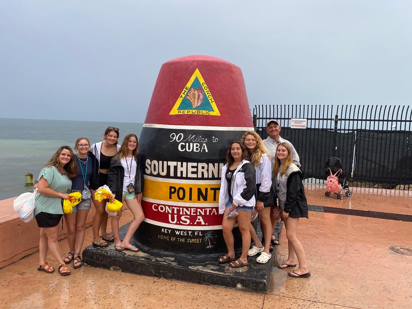 adventures for all group posing next to the conch republic pillar in key west florida