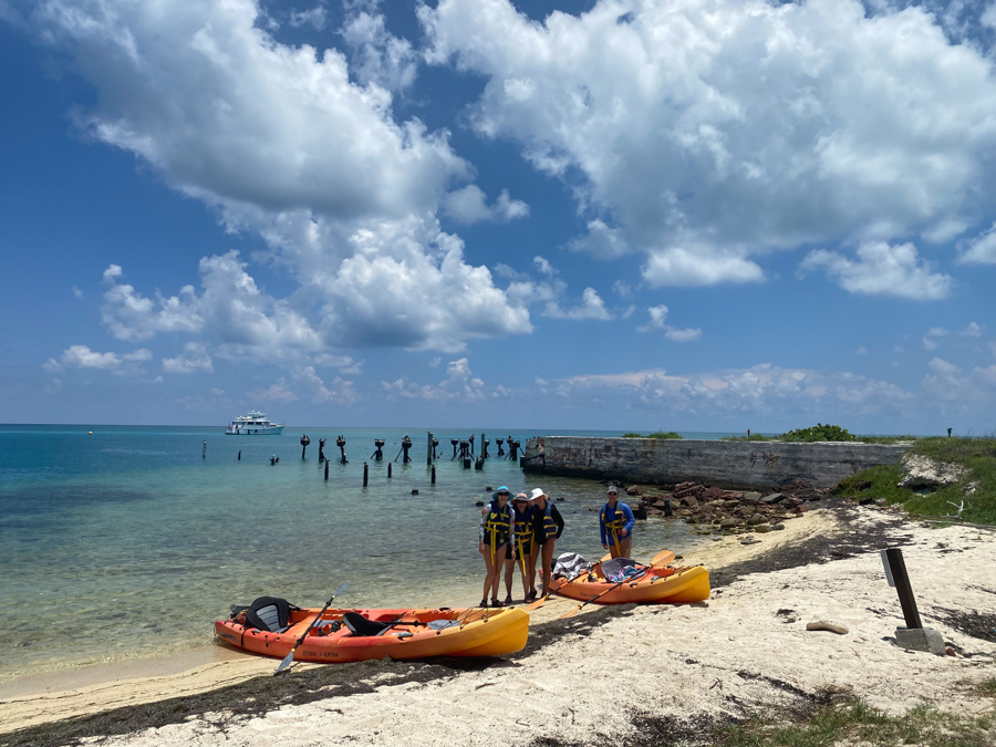 adventures for all members posing on the beach in the dry tortugas preparing to go kayaking