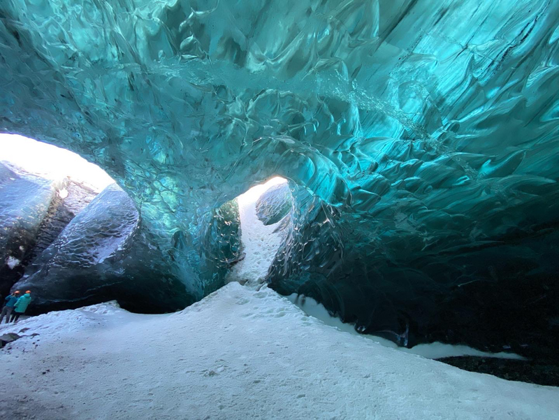 reflective teal-colored ice in the ice caves of iceland