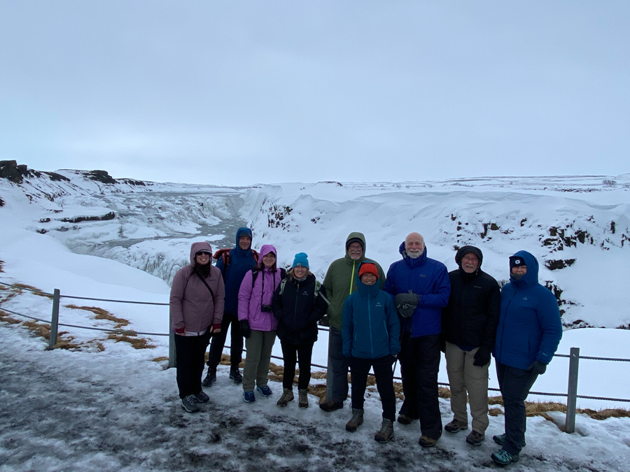 adventures for all group members smiling and standing in front of a snow covered landscape