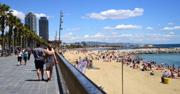 people visiting a boardwalk and beach in spain