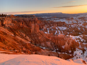 snow covered mountains and canyons during a sunset