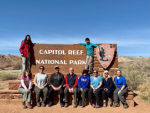 adventures for all group posing with the capitol reef national park sign