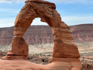 adventures for all member posing with his hands and standing under a natural stone arch