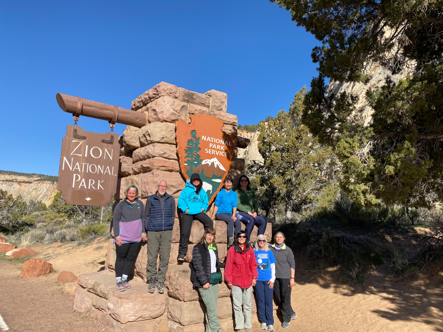 adventures for all group posing against the Zion National Park sign