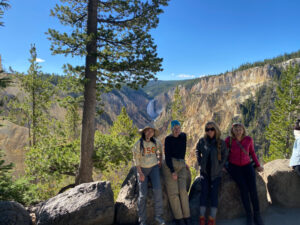 adventures for all group resting on rocks after hiking to see the view of a distant waterfall