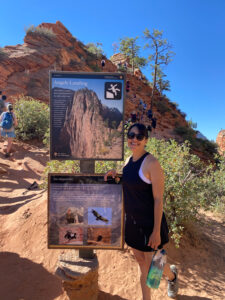 adventures for all member posing by angels landing sign