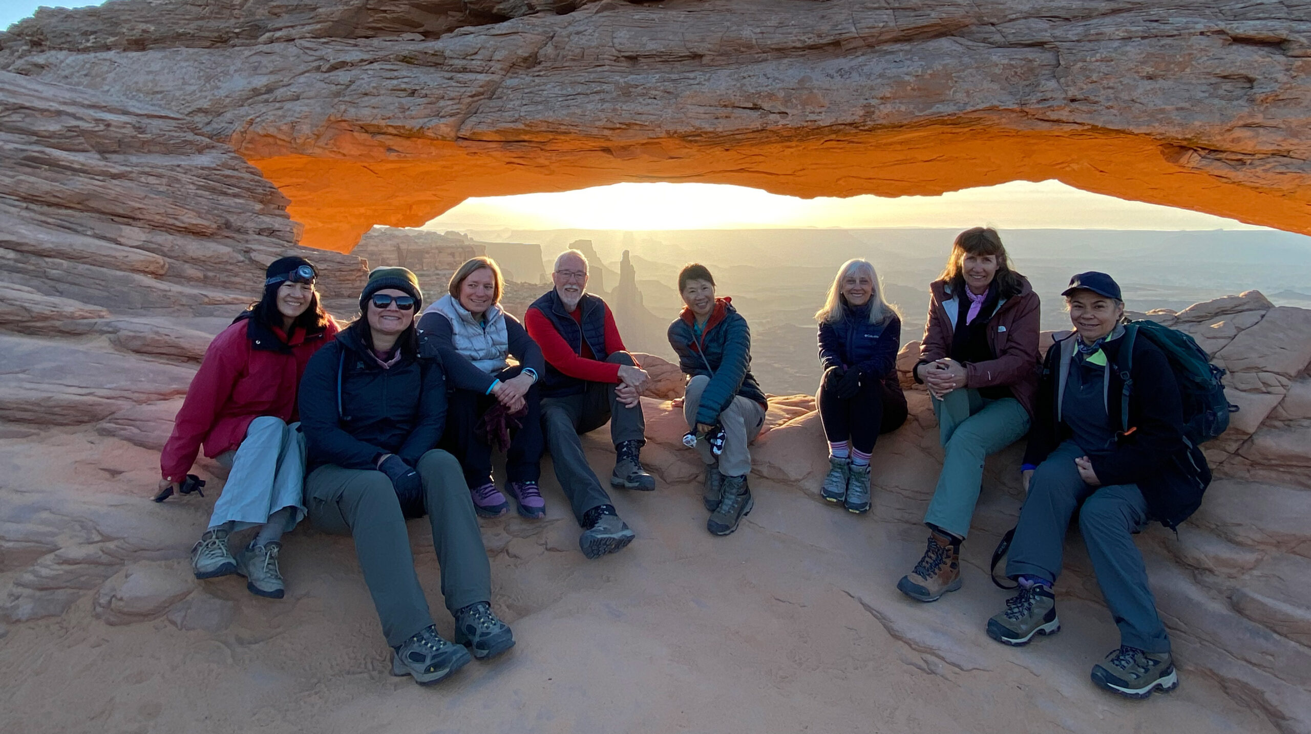 adventures for all group sitting near the rock arches in utah during a sunset