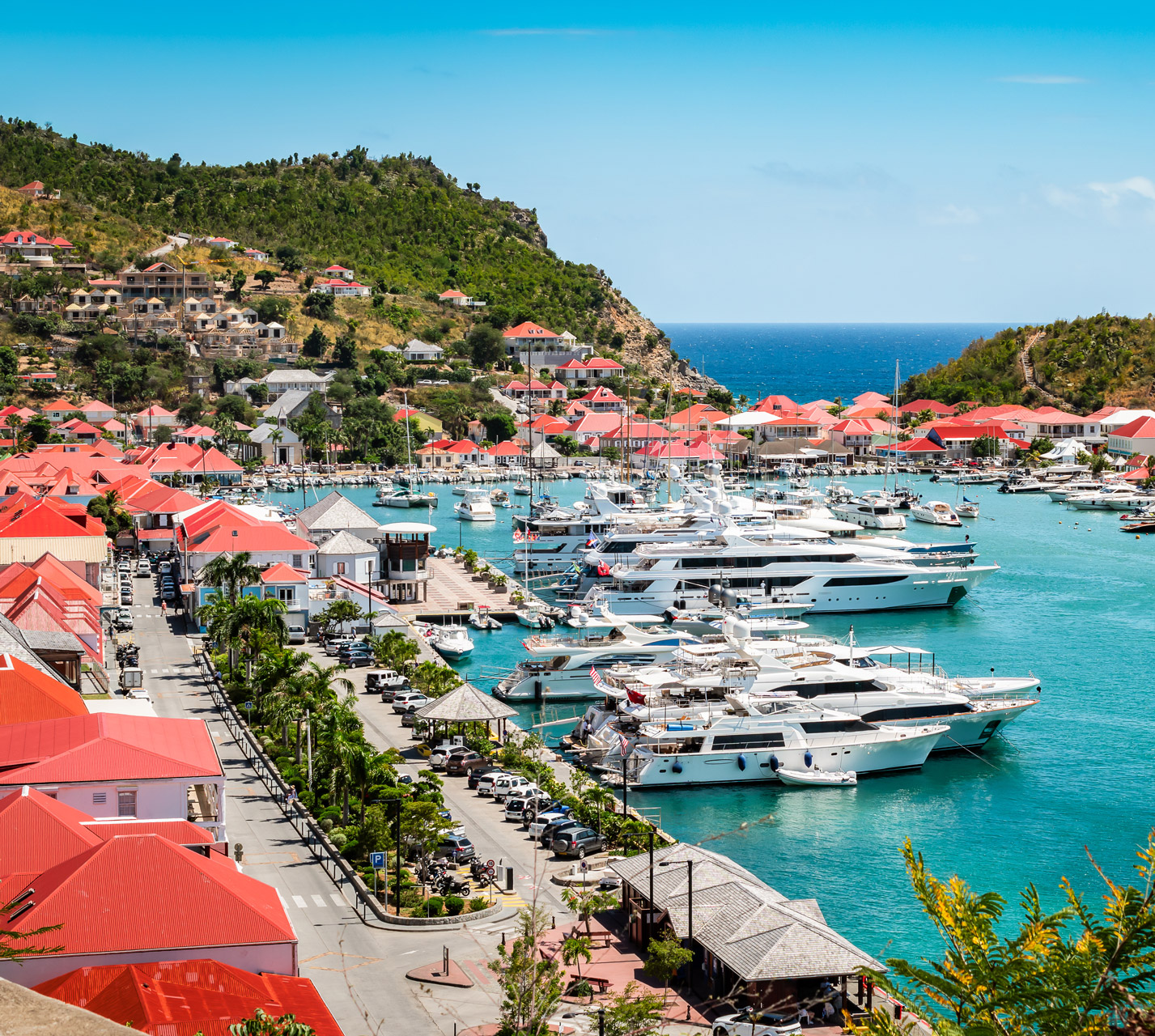 shipyard in st barts on a clear day surrounded by buildings with red roofs