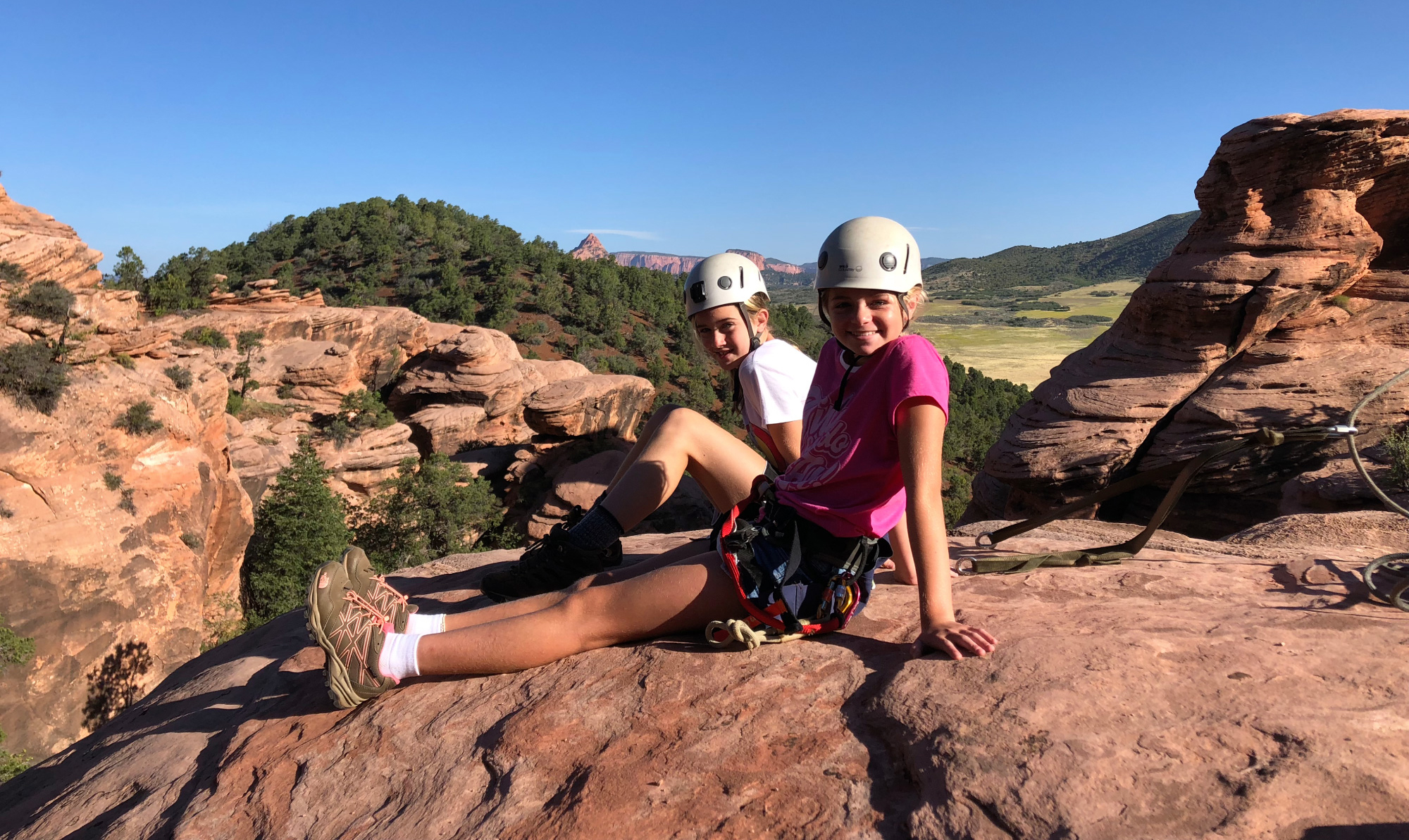 two youth educational adventures group members sitting on red rocks
