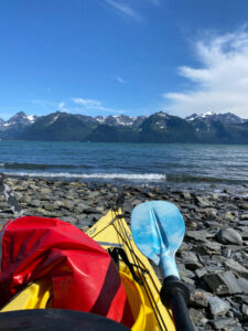 view from a kayak resting on rocky shores by calm waters