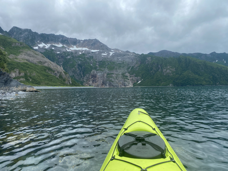 view from a lime green kayak on calm waters in alaska