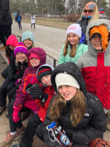 youth educational adventures group sitting on a bench and smiling as it snows
