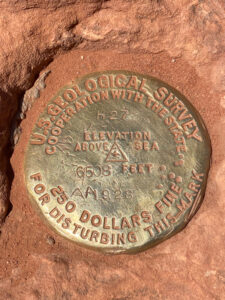 metal landmark sign from the US Geological Survey resting on rocks in zion national park