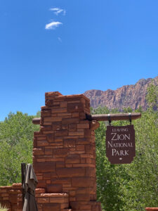 leaving zion national park sign posted on a brick column